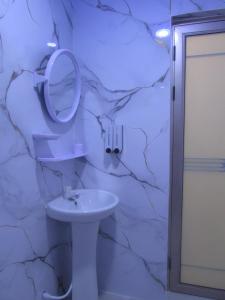 a bathroom with a sink and a mirror on a stone wall at Gk Eleven in Himmafushi