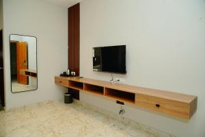 a room with a tv on a wall with a mirror at AAryavarth suites 46 in Pālasmudram