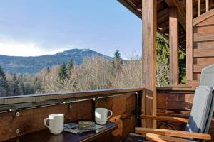 a porch with a table and chairs and mountains at Hotel Haus Anna in Bayerisch Eisenstein