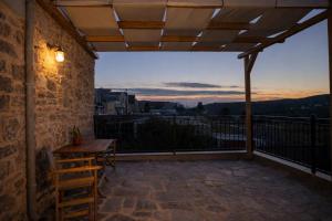 a patio with a table and chairs on a balcony at Stone Olympi Lodges - Chios Cozy Hideaways in Olýmpoi