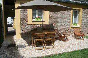 - une table et des chaises avec un parasol sur la terrasse dans l'établissement Gîte Pays D'Auge Lisieux Centre, à Lisieux