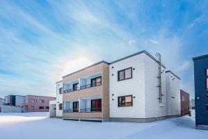 a white building with snow in front of it at Hills Niseko 105 in Niseko