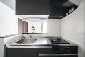 a kitchen with a sink and a stove at Hills Niseko 105 in Niseko