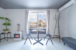 a room with a table and chairs and a window at Hills Niseko 105 in Niseko
