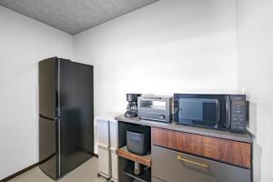 a kitchen with a microwave and a refrigerator at Hills Niseko 105 in Niseko +52 photos