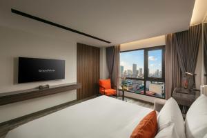 a hotel room with a bed and a flat screen tv at GrandView Hotel & Residence Hanoi in Hanoi