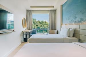a hotel room with two beds and a window at Cititel Express Kota Kinabalu in Kota Kinabalu +50 photos