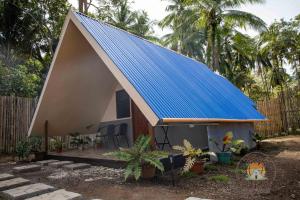 a small house with a blue roof with a porch at Lukay Guest House in Siquijor in Lazi