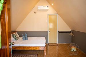 a small bedroom with a bed in a attic at Lukay Guest House in Siquijor in Lazi