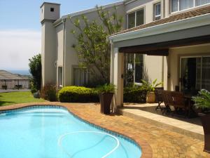 a swimming pool in front of a house at Bella Vista Guest House La Lucia Umhlanga in Durban