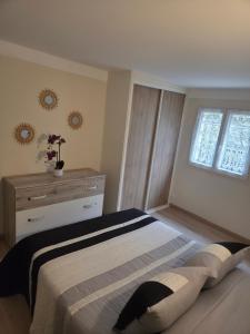 a bedroom with a bed and a dresser and a window at Le chemin du bonheur in Nyons