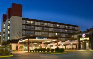 a large building with a parking lot in front of it at Hotel Ruby Foo's in Montréal