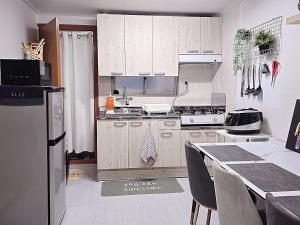 a kitchen with white cabinets and a table with chairs at Your Stay in Seoul +17 photos