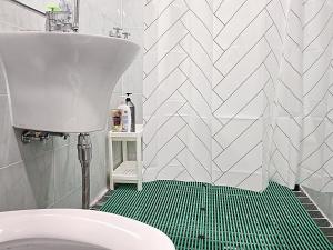 a bathroom with a toilet and a green floor at Your Stay in Seoul