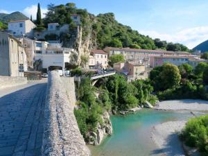a bridge over a river in a town at Le chemin du bonheur in Nyons