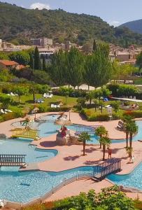 a resort with a large pool with trees and water at Le chemin du bonheur in Nyons
