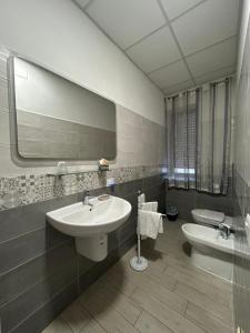 a bathroom with a sink and a toilet and a mirror at La Suite in Cassino