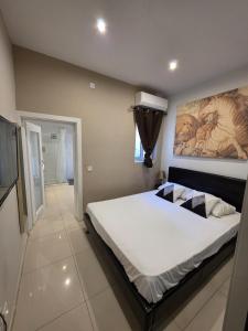 a bedroom with a large bed with a painting on the wall at Charming Valletta Escape Unesco Area in Valletta