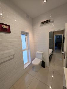a white bathroom with a toilet and a window at Charming Valletta Escape Unesco Area in Valletta