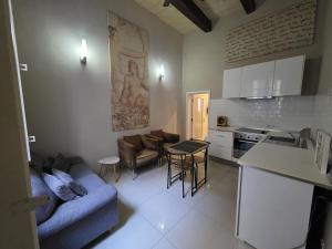 a kitchen and living room with a couch and a table at Charming Valletta Escape Unesco Area in Valletta