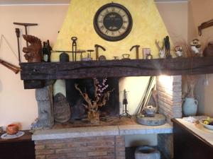 a fireplace with a clock on top of it at Al Vecchio Camino in Rotonda +104 photos