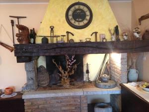a fireplace with a clock on top of it at Al Vecchio Camino in Rotonda