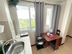 a bathroom with a sink and a desk with a window at Potot Haven Dorm and Transient in Libmanan