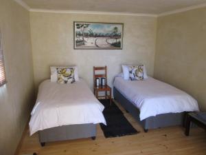 a bedroom with two beds and a picture on the wall at Nardouw in Clanwilliam