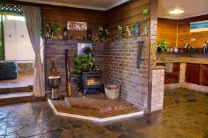 a brick fireplace with a stove in a room at On The Wallaby Eco Lodge in Yungaburra +55 photos
