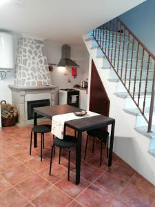 a kitchen with a table and chairs and a staircase at 9, Cimo da Aldeia in Aldeia de João Pires