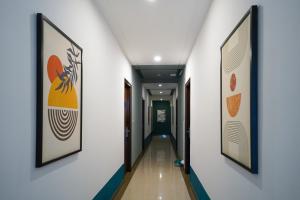a corridor in a hospital with paintings on the walls at Olive Zip Rest House Road by Embassy Group in Bangalore +41 photos