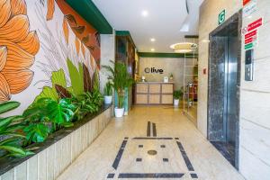 a lobby of a building with plants on the wall at Olive Zip Rest House Road by Embassy Group in Bangalore