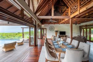 a dining room with a long table and chairs at Khaya Luxury Villas Nusa Dua in Nusa Dua