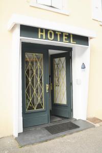 um hotel com uma porta verde e uma placa em Hotel Morez em Morez