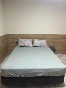 a bed with two pillows on top of it at Refúgio ao mar in Rio das Ostras