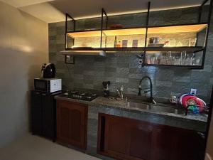 a kitchen with a sink and a stove at Refúgio ao mar in Rio das Ostras