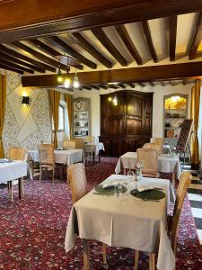 a dining room with tables and chairs in a restaurant at Logis Hotel Le Prince Noir in Sérignac-sur-Garonne