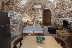 a bedroom with a bed in a stone walled room at Vlychos Olympi Lodges - Chios Cozy Getaways in Olýmpoi