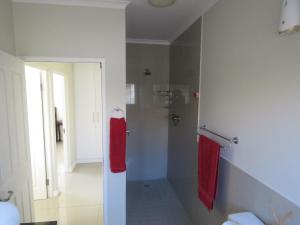 a bathroom with a shower with two red towels at the range in Langebaan +6 photos