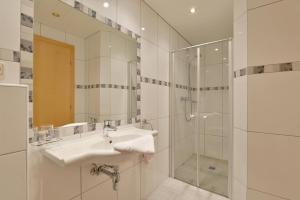 a white bathroom with a sink and a shower at Gasthof Appartement`s Staffnerhof in Kössen +32 photos