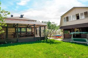 a house with a covered porch next to a yard at Aqualife Spa hotel on Leninskogo Komsomola in Cheboksary