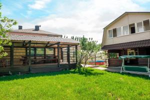 une maison avec une terrasse couverte à côté d'une cour dans l'établissement Aqualife Spa hotel on Leninskogo Komsomola, à Tcheboksary