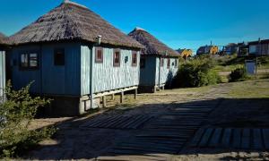 a row of houses with thatched roofs on a street at Cabañas Las Achiras in Punta Del Diablo