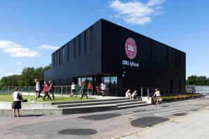 a black building with people walking outside of it at DBU Hotel & Kursuscenter in Aarhus