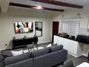 a living room with a couch and a tv on the wall at 6ALouieVille in Lusaka