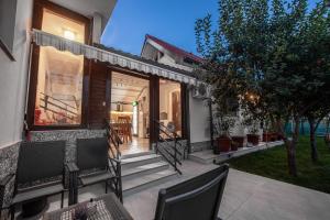 a home with a porch with chairs and trees at Vila H2O in Mangalia +17 photos