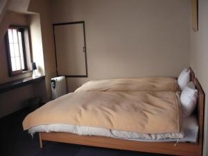 una camera con un grande letto e uno specchio di Oyado Nozawaya a Nozawa Onsen