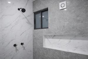 a bathroom with a shower with a sink and a window at Depto Tec by tuhost in Monterrey