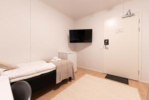 a bedroom with a bed and a tv on a wall at LODGE Hostel Ylläs in Äkäslompolo