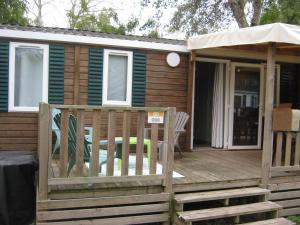 a cabin with a wooden deck with an umbrella at erick in Angles +5 photos
